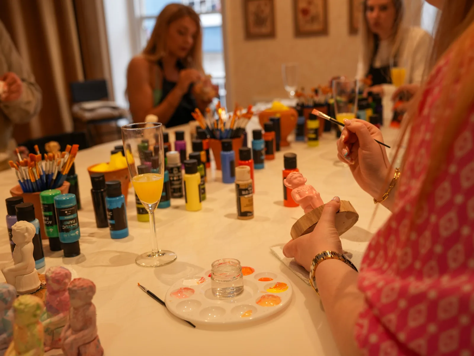 A table laid with paints, brushes and imps ready for a Sip & Paint session